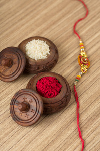 印度节日 罗刹 Bandhan 的背景优雅 Rakhi, 大米谷物和 Kumkum。一个传统的印度手腕带, 这是兄弟姐妹之间的