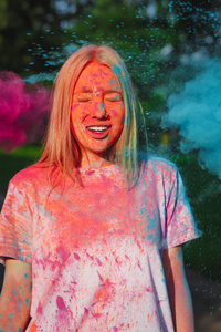 可爱的白种女孩与爆炸的蓝色和粉红色干燥的节日油漆摆造型