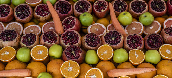 水果 石榴, 苹果, 橙 和蔬菜 胡萝卜 在土耳其伊斯坦布尔的大市集的食品摊位上的介绍