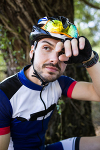 英俊的年轻男子骑自行车在山后放松