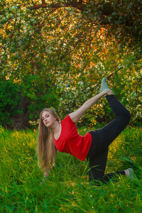 做瑜伽户外在绿色草地上的美丽女人