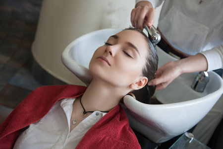 美发沙龙中的视图理发师洗头理发师洗头在美发沙龙的女人发型师洗头的