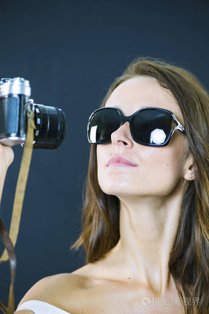 可爱的时尚黑发女孩手里拿着一台旧相机照片-正版商用图片0ro5ph-摄图