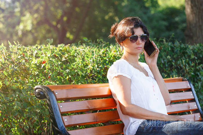照片 人物 一位中年妇女坐在公园长椅上.