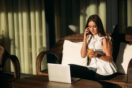 年轻漂亮的女孩在休息在工作过程中使用一台笔记本电脑