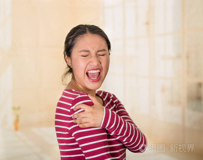 年轻西班牙裔女子摆姿势让你相机的肩部疼痛迹象手上痛苦的身体部位