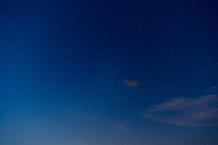 夜晚明亮的天空中有星星和一朵小云彩