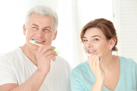 清洁牙齿在家里的年长夫妇