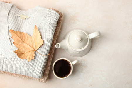 暖秋季毛衣和茶中性背景。概念秋季服装