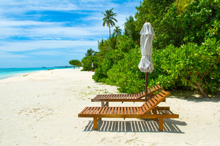 美丽的海滨沙滩日光浴浴床与撑着雨伞,印度洋马尔代夫岛照片