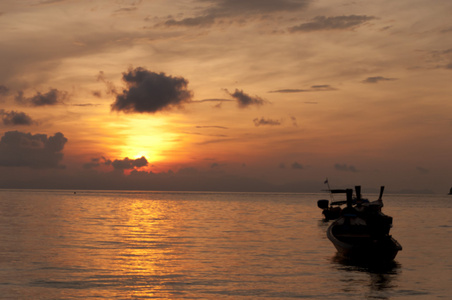 模糊的轮廓传统长尾船海上夕阳光