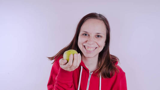 雌性手在白色背景下保存绿色水果, 关闭。女孩的脸抱着新鲜的苹果。园艺和秋季概念。妇女提供本土收获