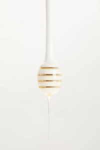 在白色背景下, 用有机蜂蜜加深木蜂蜜的特写