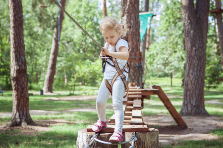 儿童休闲活动。小女孩在绳索公园玩得开心