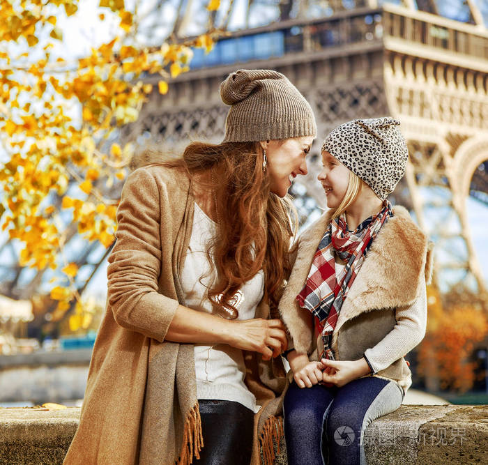 巴黎埃菲尔铁塔附近路堤上微笑的母亲和儿童旅行者的肖像在法国享受