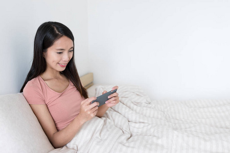 女人在卧室里面的手机玩游戏图片