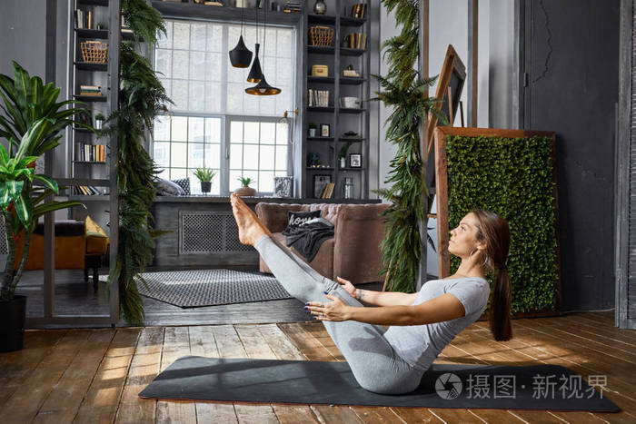 在客厅里女人练习高级的瑜伽