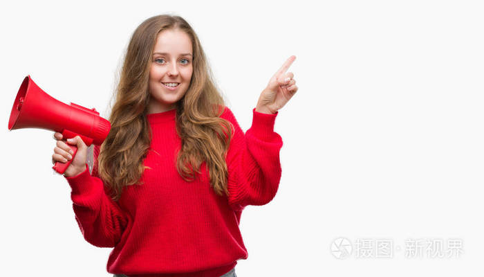 年轻的金发女郎手持红色扩音器非常高兴地指着手和手指的侧面