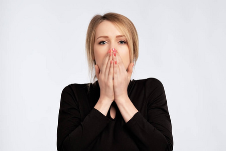 白种人伤心的惊讶激动的女人穿件黑衣服,用手捂着嘴与空白 copyspace