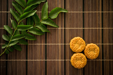 中秋佳节, 传统糕点月饼被吃掉。Flatlay 在桌上, 上往下看暗光与复制空间。月饼中的汉字代表英语中的 莲花糊