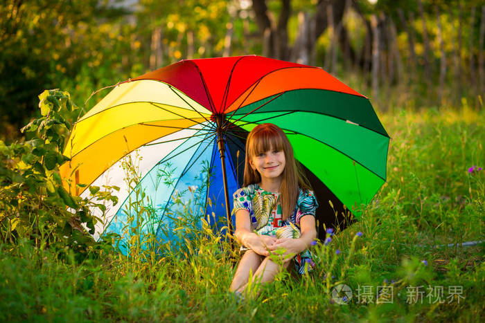 快乐的孩子女孩漫步与多彩多姿的雨伞下夏季雨