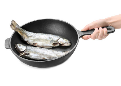 手拿着煎锅与鱼