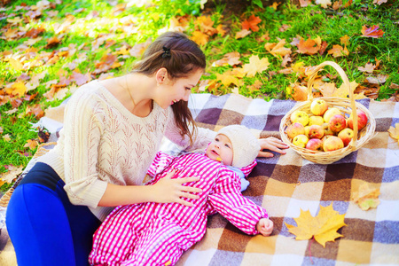 快乐妈妈和宝宝在秋天公园野餐