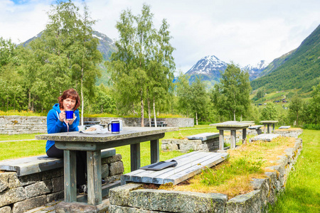 旅行者女人对挪威山区自然吃午饭