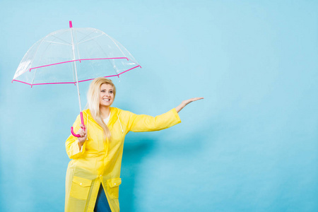 女人穿着雨衣打着伞检查天气