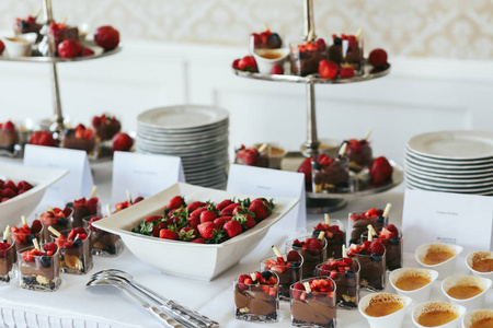 碟子和盘子的成熟草莓和巧克力甜点