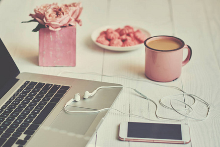 女性工作空间worksplace 键盘, 咖啡和鲜花。一束玫瑰, 一杯咖啡和笔记本电脑放在老木桌上。创意规划理念。顶部视图。色