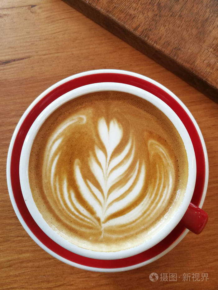 一杯拿铁的艺术咖啡在木制背景下照片-正版商用图片0rrptu-摄图新视界