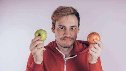 男子持有红色和绿色的苹果孤立的白色背景。园艺与秋季农作物的概念