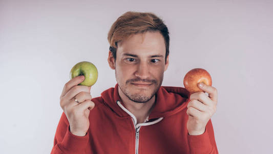 男子持有红色和绿色的苹果孤立的白色背景。园艺与秋季农作物的概念