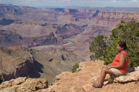 女人坐在大峡谷的边缘上