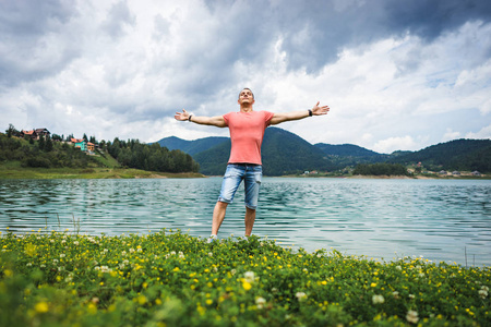 一个人独自站在塞尔维亚的 zaovine 湖上紧握双手, 感受自由照片