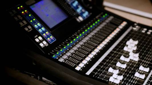 录音工作室音频控制台和一只手拉起旋钮音频控制台的 4 k 镜头。