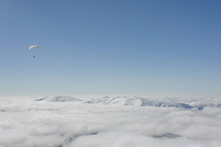 滑雪在云层上空飞向蓝天和雪山