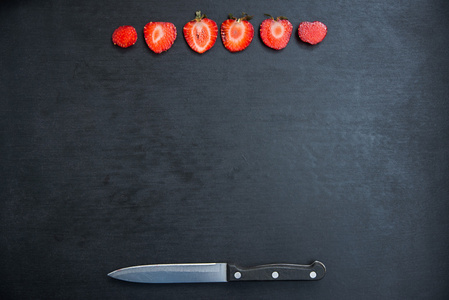 草莓和黑色背景上的刀