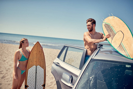 夏季假期道路旅行假期年轻的冲浪夫妇在海滩上准备冲浪