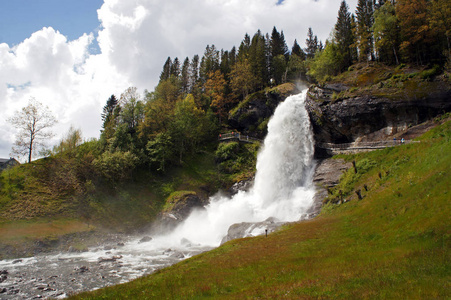 Steinsdalsfossen 瀑布中半胱氨酸在河景观与叶栅环绕山和传统的挪威，斯堪的纳维亚的房子