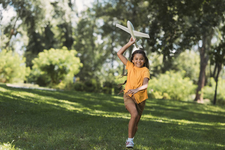 可爱的快乐孩子投掷玩具飞机在公园