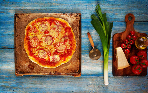 木制餐桌上的原料披萨配料。准备古典比萨。在比萨里加奶酪。意大利食品自制概念