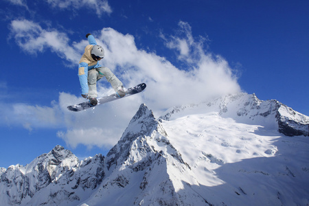 滑雪板骑手跳跃于群山之巅。极端的滑雪随心所欲的运动