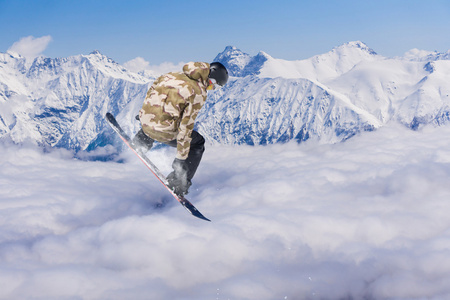 滑雪板骑手跳跃于群山之巅。极端的滑雪随心所欲的运动