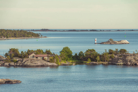 一个单独的小岛上的孤独的房子。瑞典的一间普通小屋。小灯塔矗立在岛上