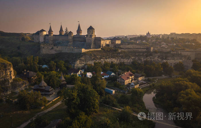 童话般的看法在 KamianetsPodilskyi 城堡, 乌克兰。日出以上 KamianetsPodilskyi 城市