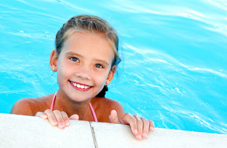 可爱的微笑快乐的小女孩在游泳池的夏天天