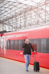 白种人年轻人带的行李在车站乘火车旅行