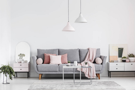 真实的照片, 优雅的客厅内部与灰色沙发, 粉红色的枕头, 橱柜和灯具